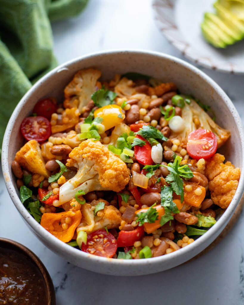 Creole Spiced Pinto bean and pearl cous cous bowl with vegetables