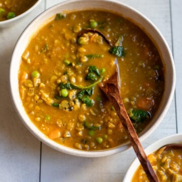 closeup of vegan split pea soup with extra veggies with a spoon