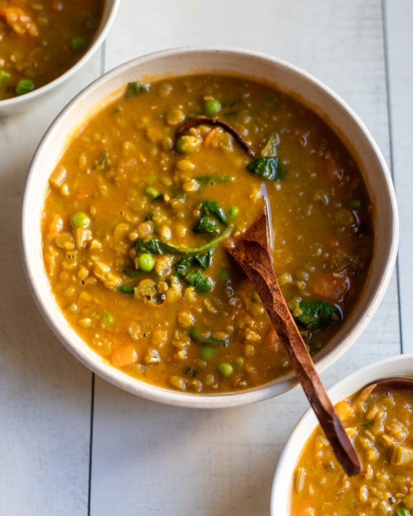 closeup of vegan split pea soup with extra veggies with a spoon