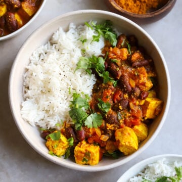 overhead view of rajma curry kidney beans with tofu in a bowl with rice and cilantro
