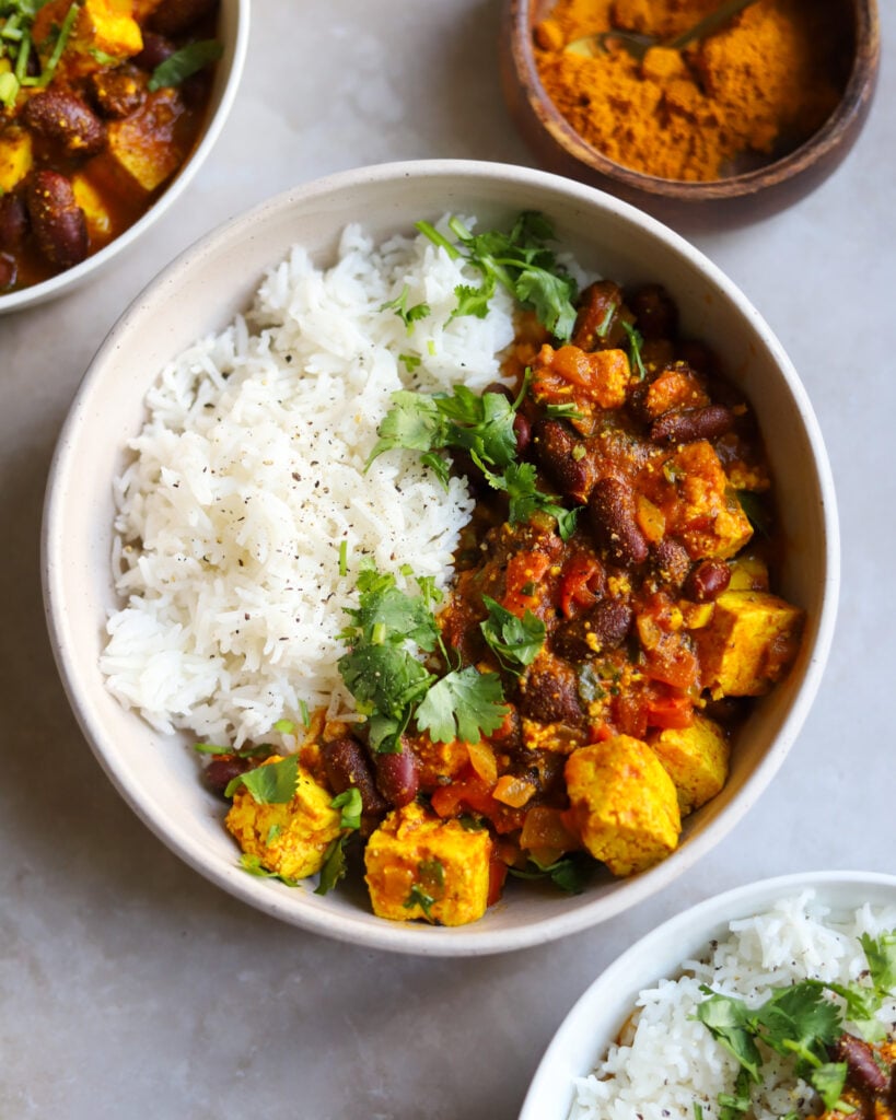 overhead view of rajma curry kidney beans with tofu in a bowl with rice and cilantro