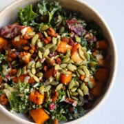Overhead view of Autumn Harvest Salad in a bowl with toasted pepitas, roasted butternut squash, tempeh, kale and radichhio