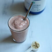 Looking down at a glass full of a light pink, thick and creamy High Protein Vegan Berry Vanilla Breakfast Smoothie