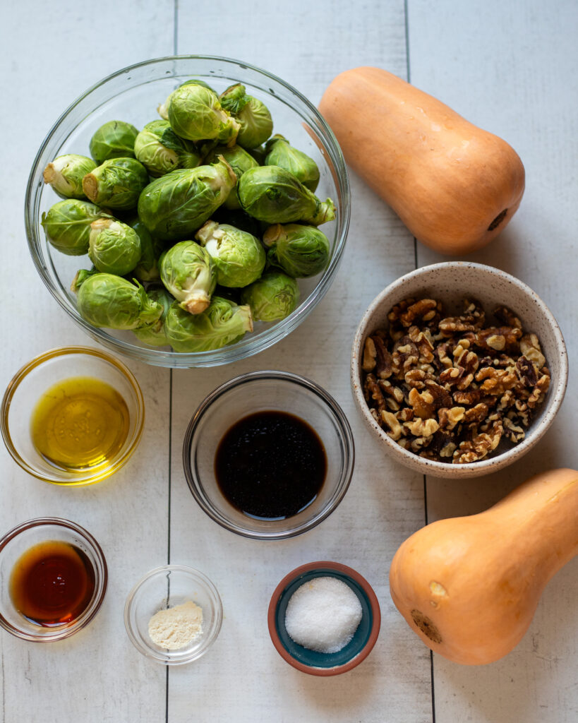 flatly of ingredients: brussels sprouts, honeynut squash, walnuts, balsamic vinegar, olive oil, pure maple syrup and salt
