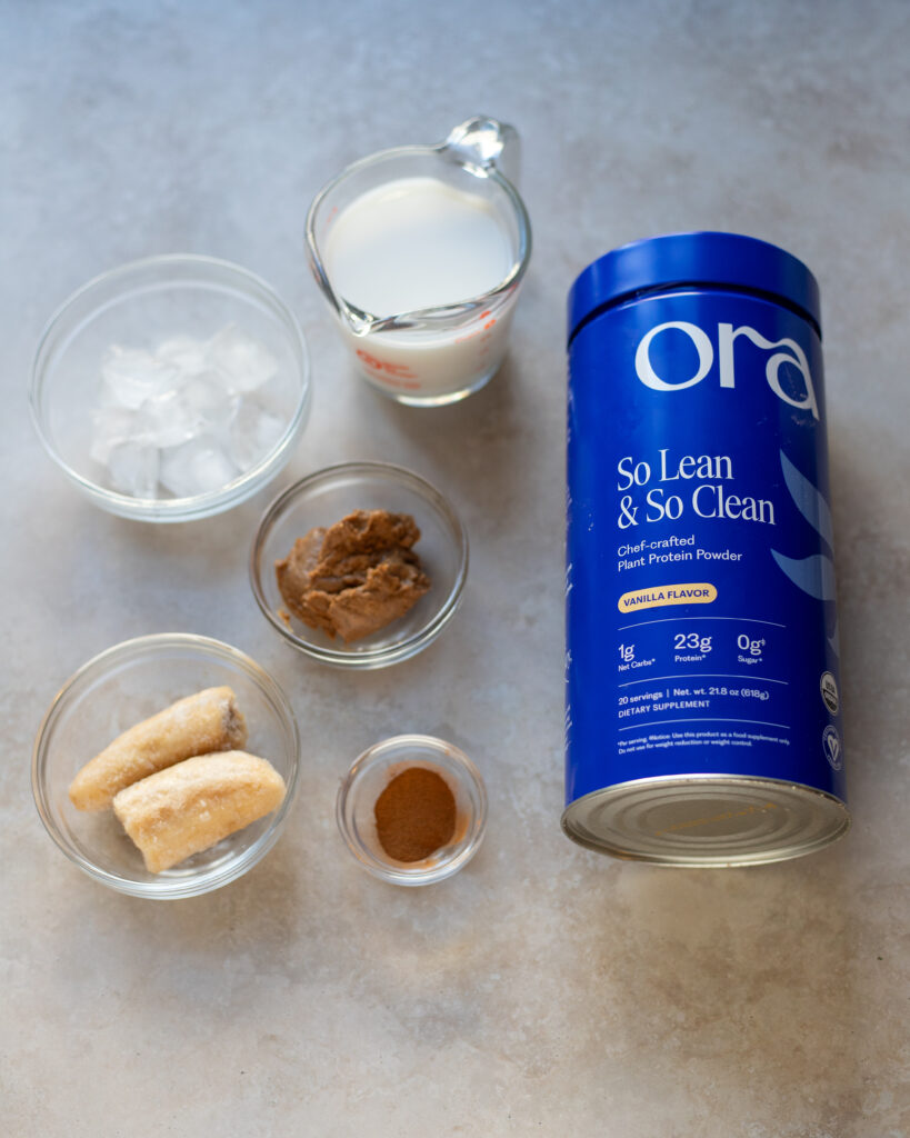 ingredients for cinnamon almond vegan protein smoothie laid out in a flat lay