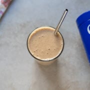 overhead view of a vegan protein smoothie with Ora protein powder tin on the side