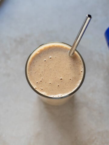 overhead view of a vegan protein smoothie with Ora protein powder tin on the side