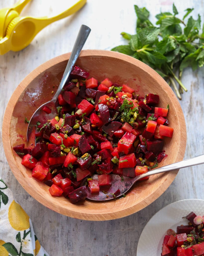 wooden salad bowl filled with a vibrant beet salad