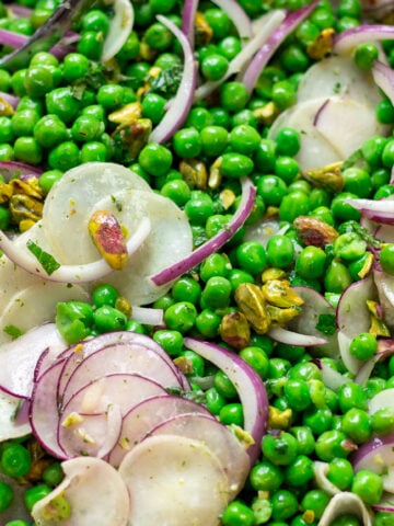 closeup of healthy pea salad with radishes, red onions, mint and pistachios