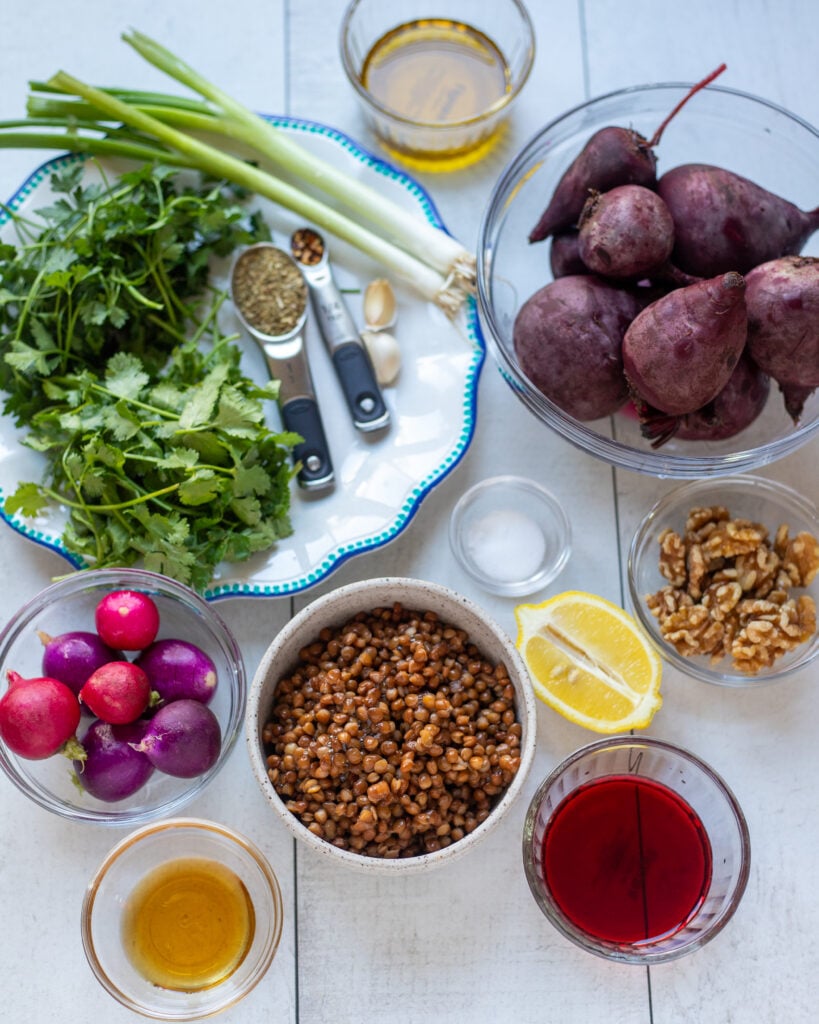 ingredients for the salad recipe laid out in small bowls, plates and spoons