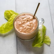 A small cup of Russian dressing surrounded by crispy lettuce