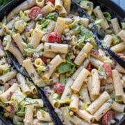 overhead view of a big black bowl filled with colorful pasta salad
