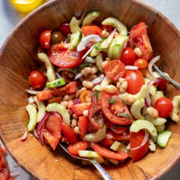 looking closer into a bowl of summer tomato salad with cucumbers, herbs and onions