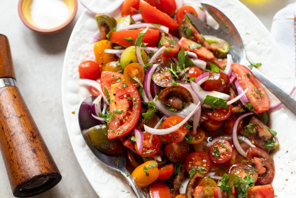 closeup view of a summer tomato and onion salad with fresh herbs