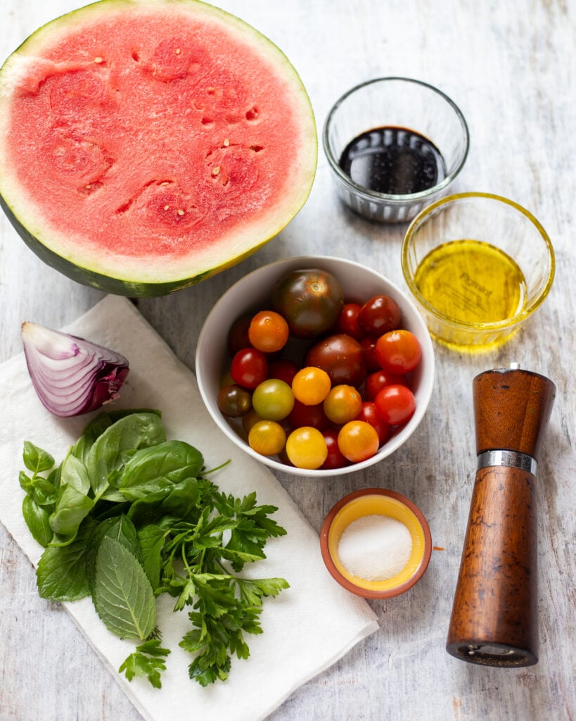 Ingredients for watermelon and tomato salad in a flatlay